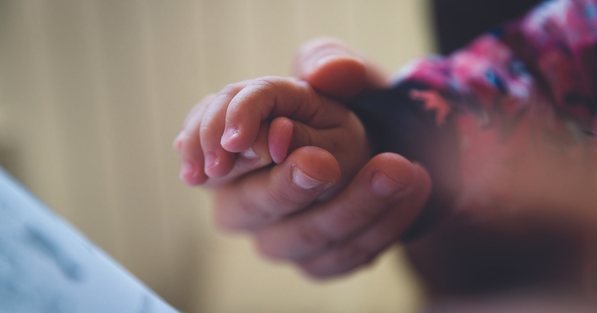Close up photo of Lana holding Minela's hands