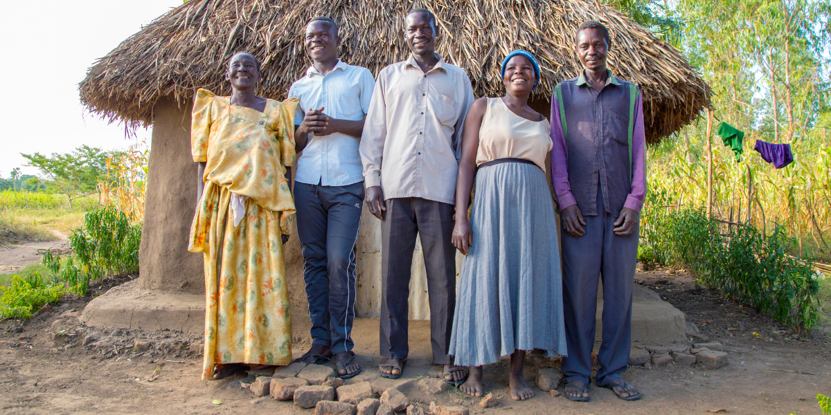 Tom and his family standing together and smiling